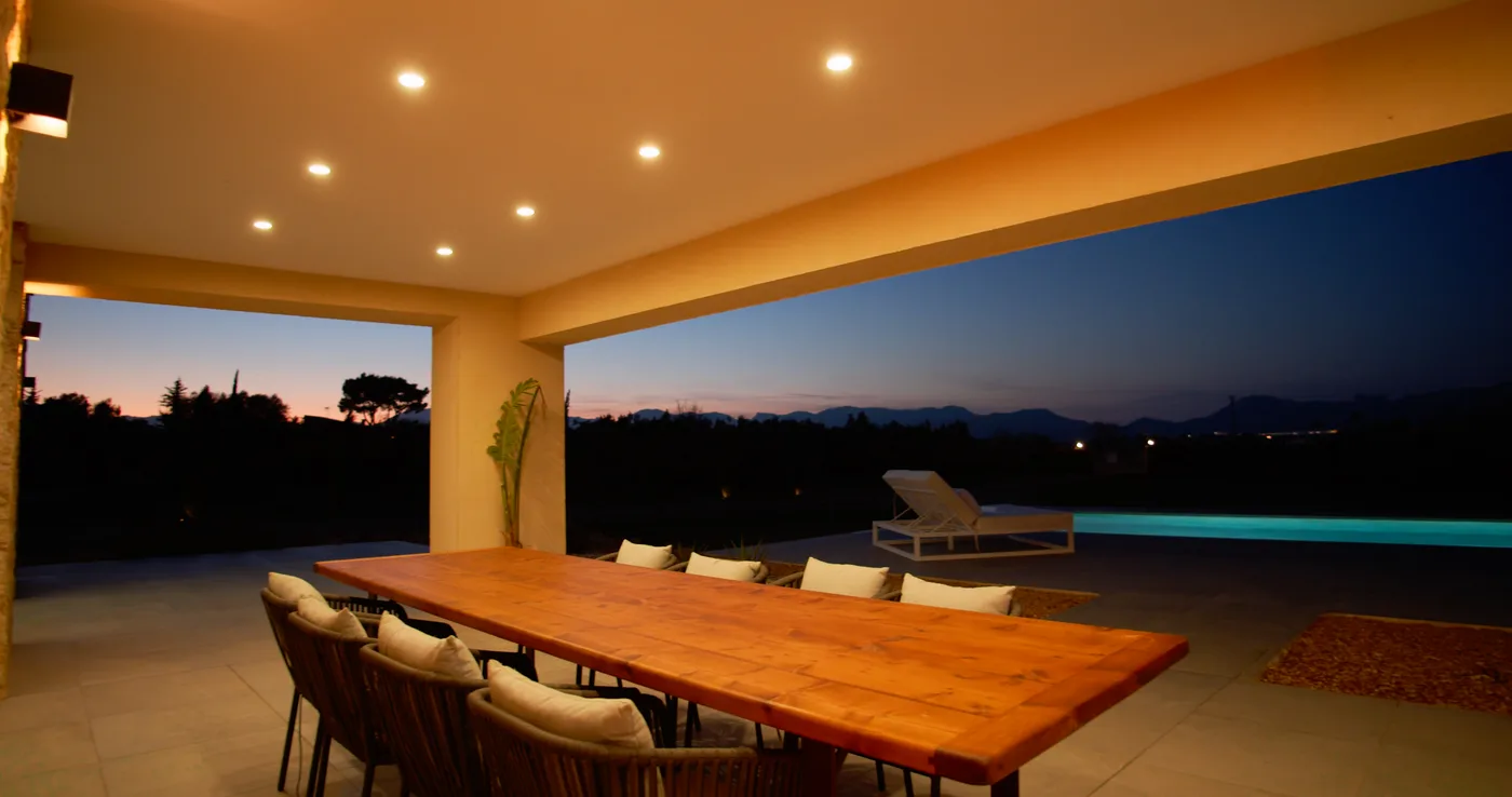 Terraza al anochecer con piscina iluminada